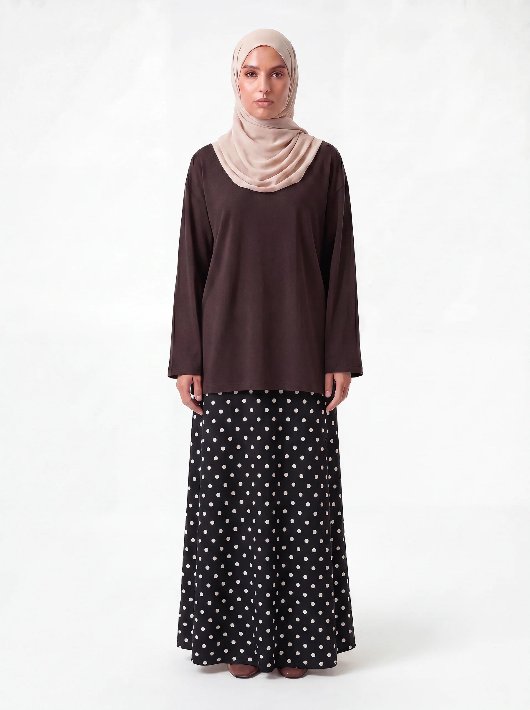 Bodenlanger schwarzer Rock mit weißen Polka-Dots und geradem Schnitt, Frontalansicht.