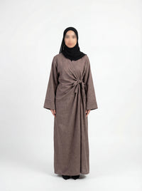 Taupefarbene Wickelabaya in Leinenoptik mit Schleifenbindung, Modest Look mit schwarzem Hijab, Vorderansicht
