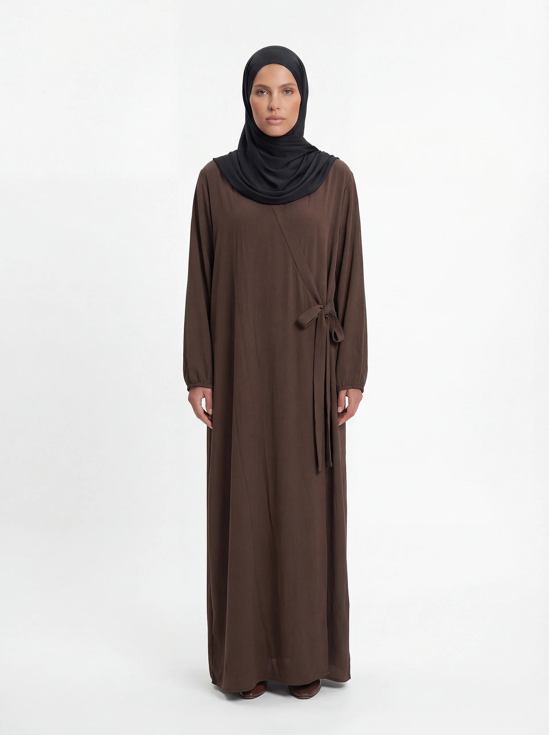 Braune Wickelabaya aus leichtem Stoff zeigt Ballonärmel und seitliche Schleife im Modest Hijab-Stil, Vorderansicht.
