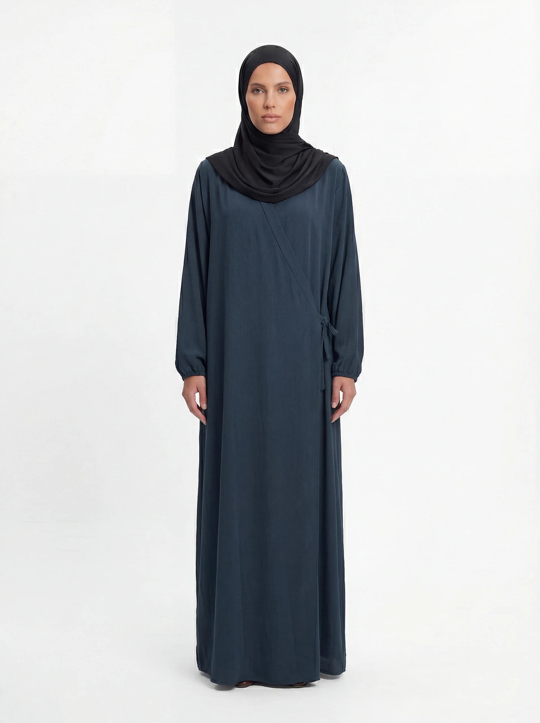 Dunkelpetrolfarbene Wickel-Abaya im Modest-Stil zeigt Ballonärmel und Seitenschleife in Vorderansicht.