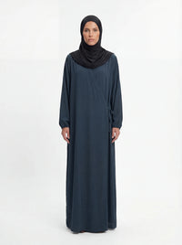 Dunkelpetrolfarbene Wickel-Abaya im Modest-Stil zeigt Ballonärmel und Seitenschleife in Vorderansicht.